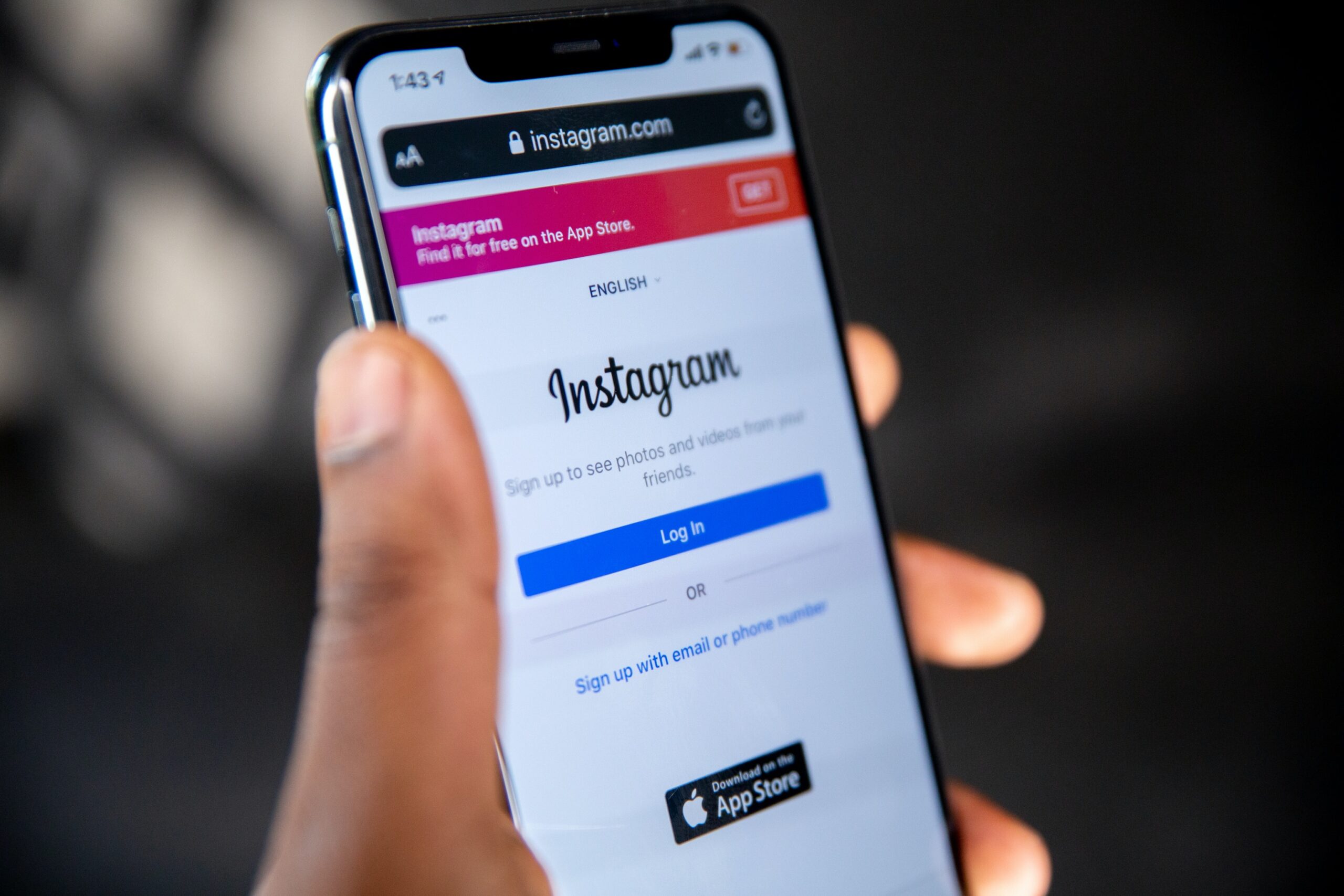 Person holding mobile device in hand with Instagram log-in page on screen